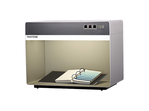 A square gray light booth, or lighting box, with a binder and color swatches.